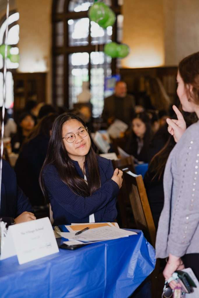 A student engaging with peers at the World Affairs Council Academic WorldQuest event, smiling and listening attentively.