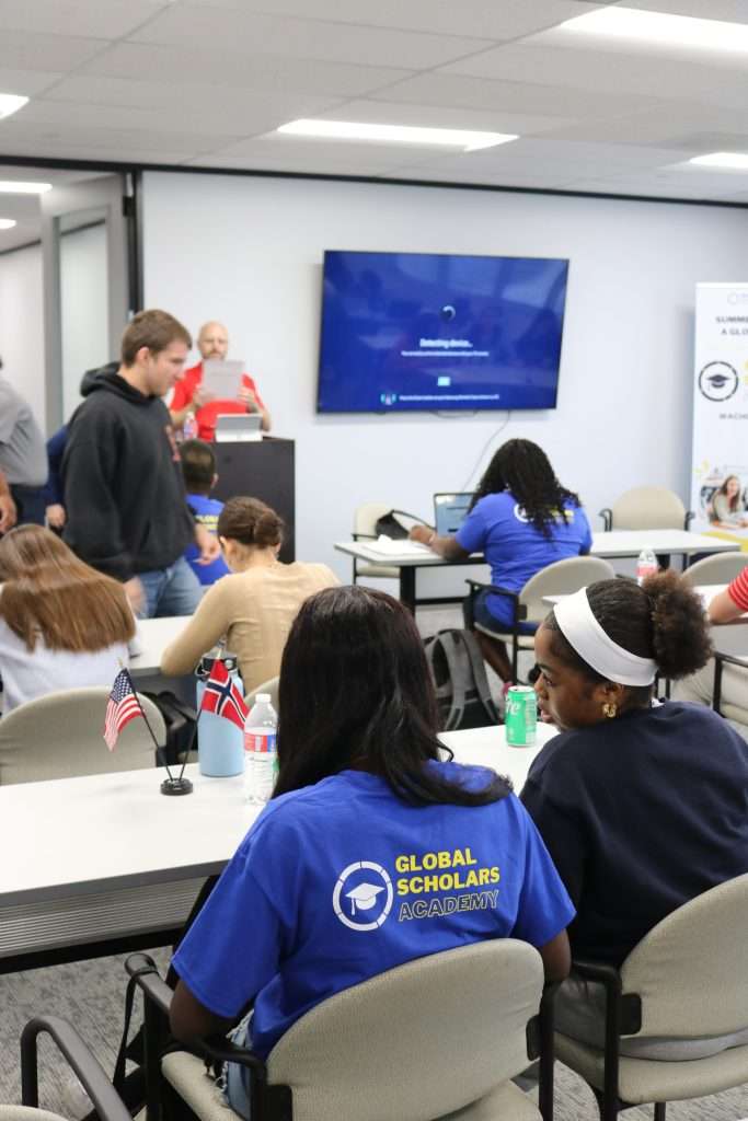 Event room filled with students, listening attentively to a presentation.